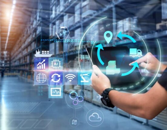 Person uses a tablet in a blurred warehouse as background
