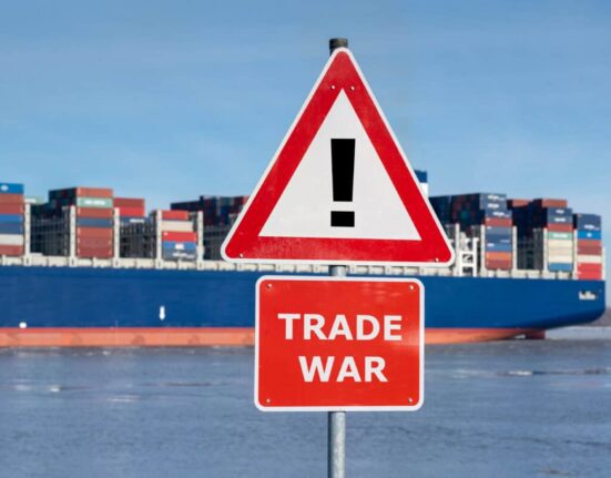 Warning sign with the text "Trade war" in front of container ship