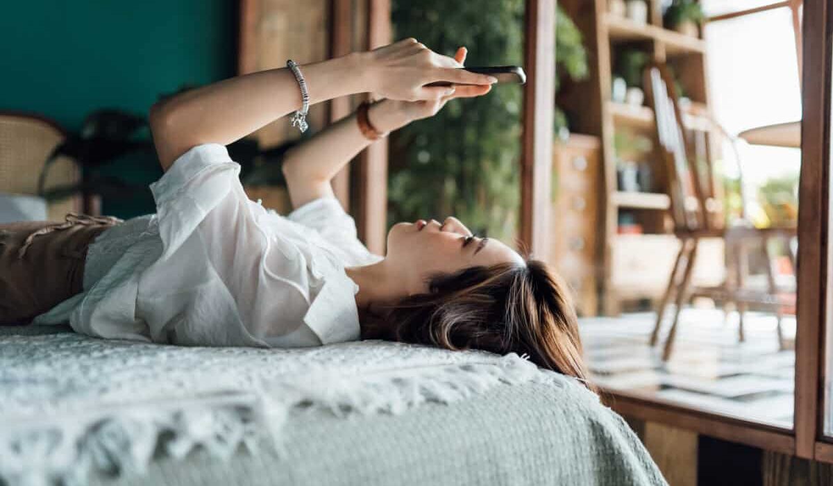 woman relaxes with phone