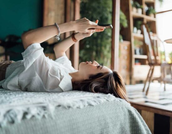 woman relaxes with phone